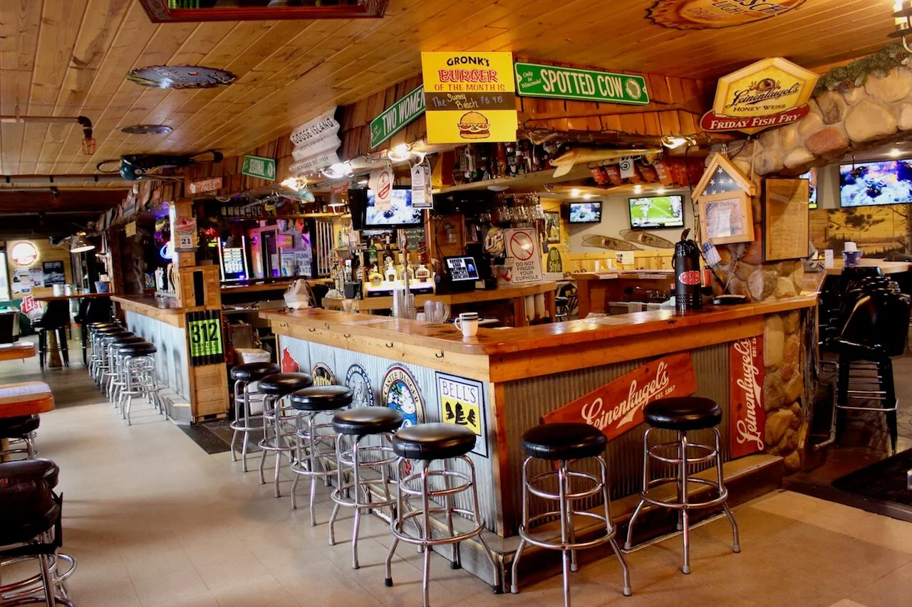 Gronk's wood lined bar with stools, beer signs and tap handles